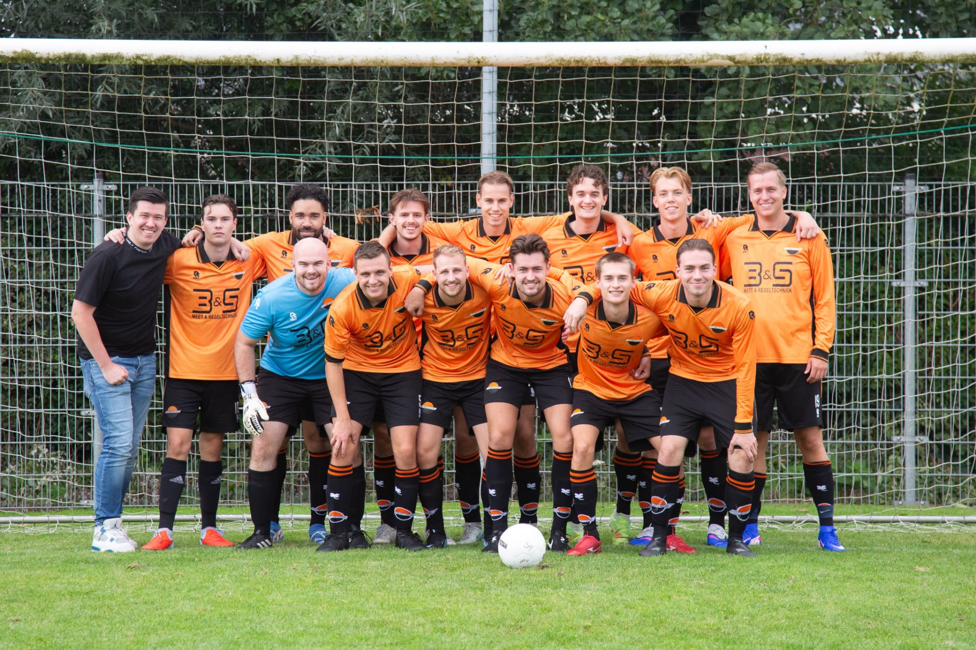 Het team van Smitshoek 8 voor het doel, in oranje-zwarte tenues.